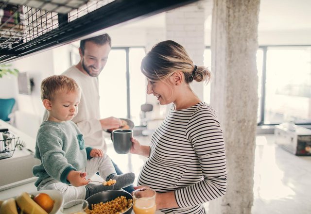 pregnant woman with son and husband cooking