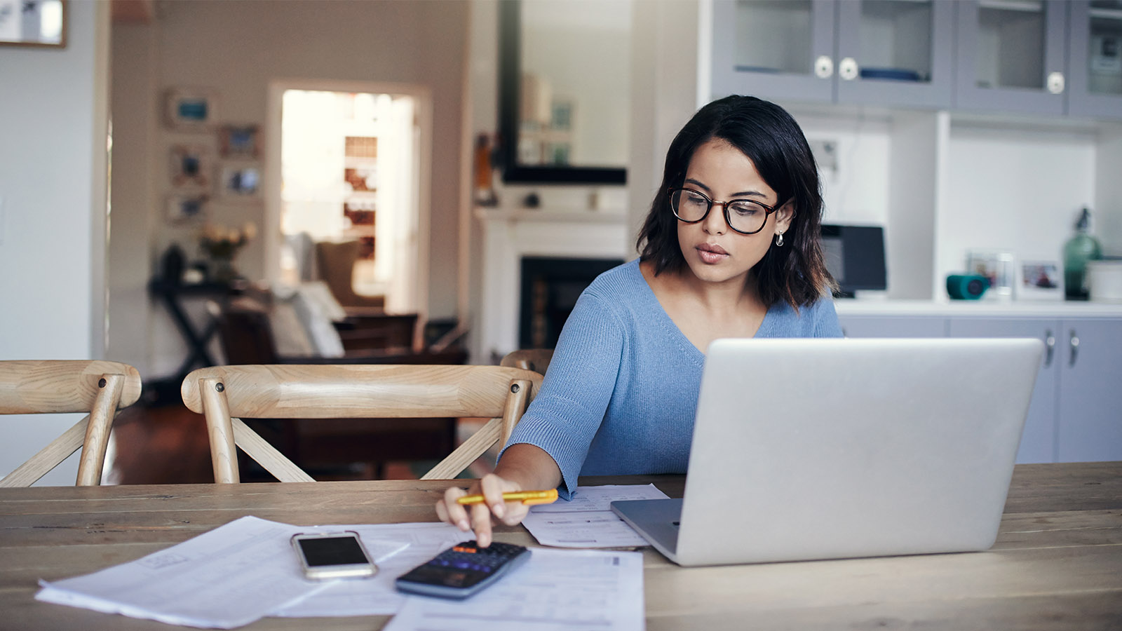 A woman calculates her business’s net income using a net income formula.