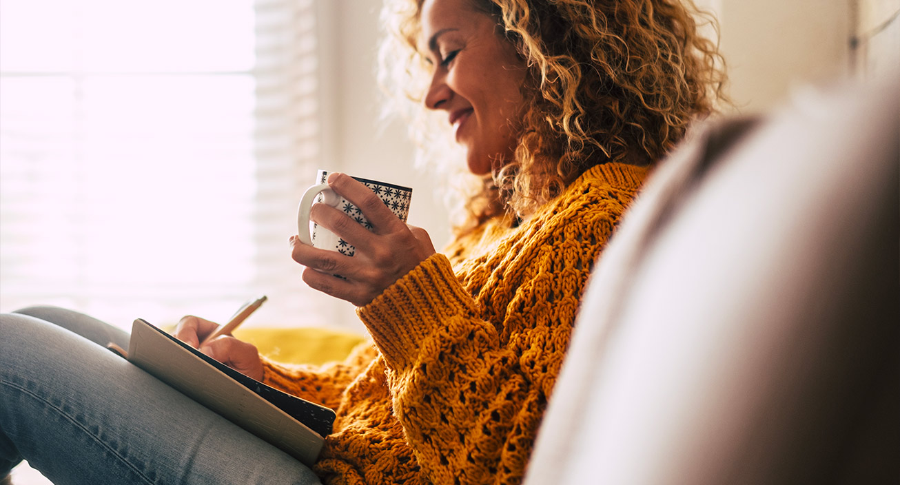 woman journaling with coffee