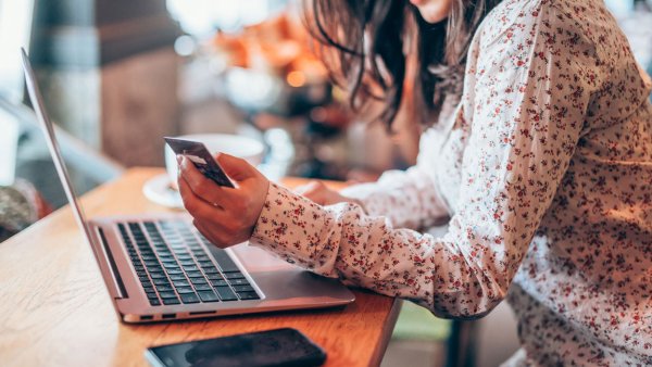 Woman holding credit card looking at laptop