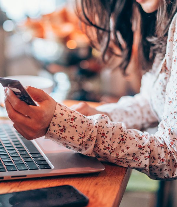 Woman holding credit card looking at laptop