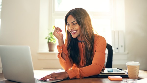 Woman sitting at laptop smiling