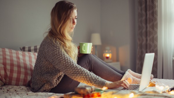 Woman working in bed on a laptop