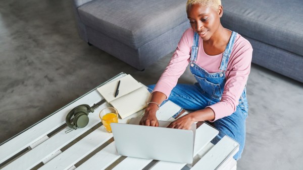 Smiling Woman Using A Laptop At Home