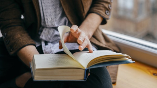 close-up-of-person-in-blazer-turning-the-page-of-a-book