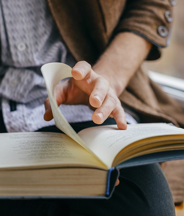 close-up-of-person-in-blazer-turning-the-page-of-a-book