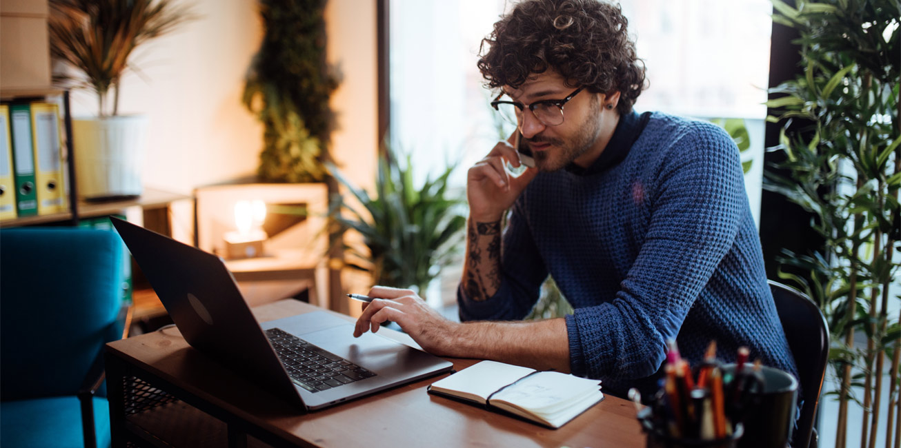 man-phone-laptop-working-home-office