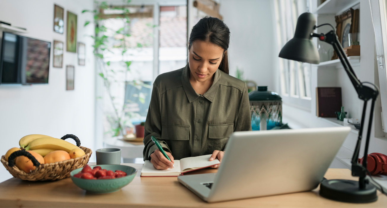 woman-freelancer-writing-notes-laptop