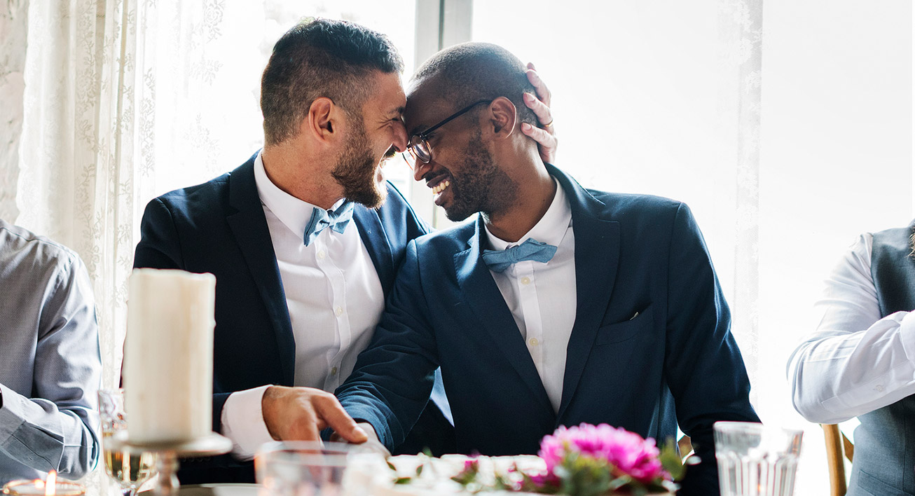 A couple embracing each other at their wedding while smiling, indicating they are happy to have used a wedding budget calculator