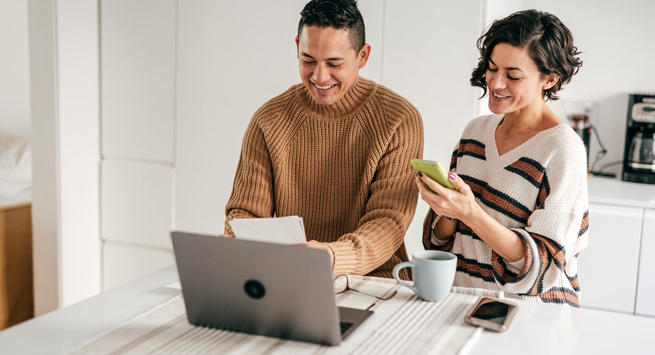 Smiling couple calculating finances.