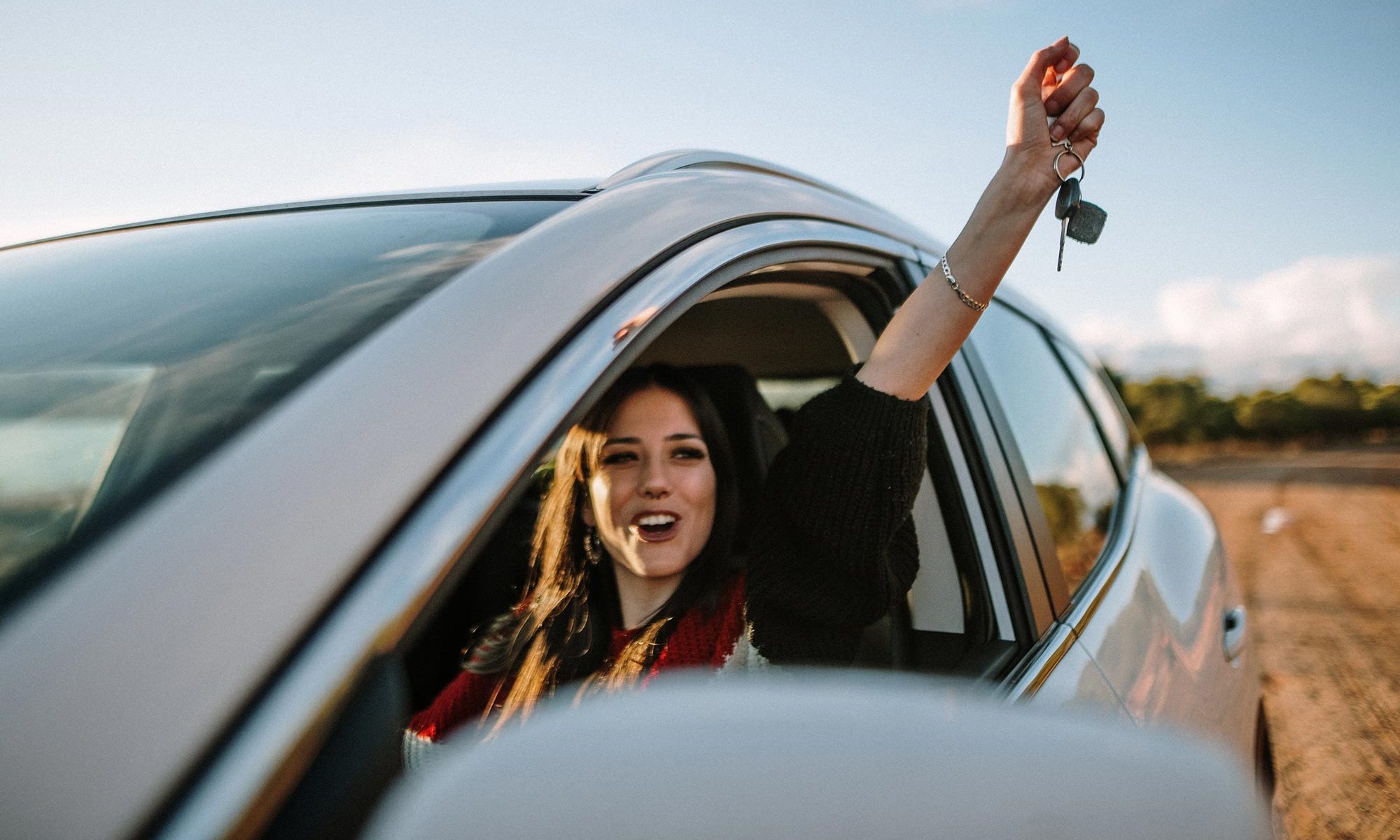 Woman holding keys in car