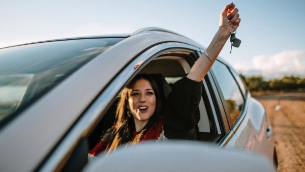 Woman holding keys in car