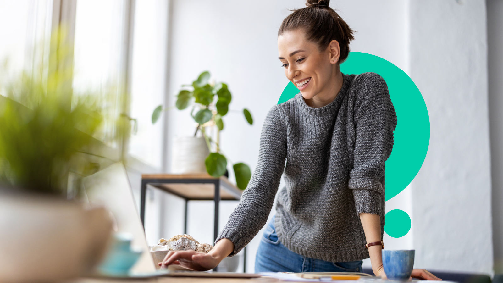 A smiling woman works at a computer