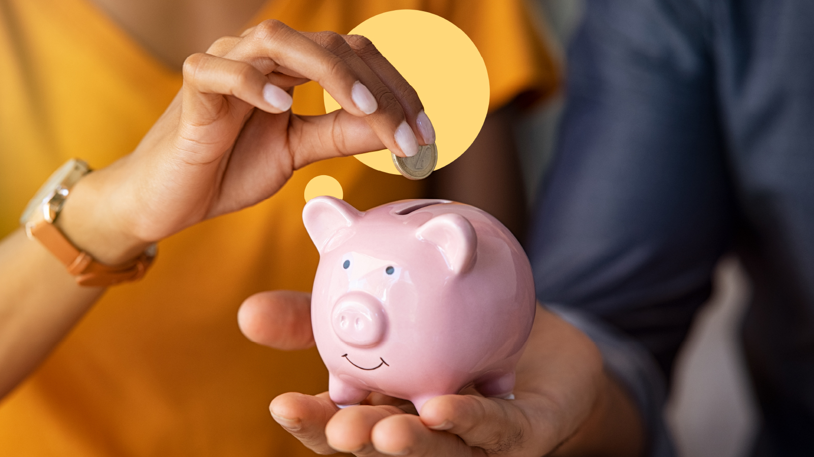 A woman places coins into a small piggy bank