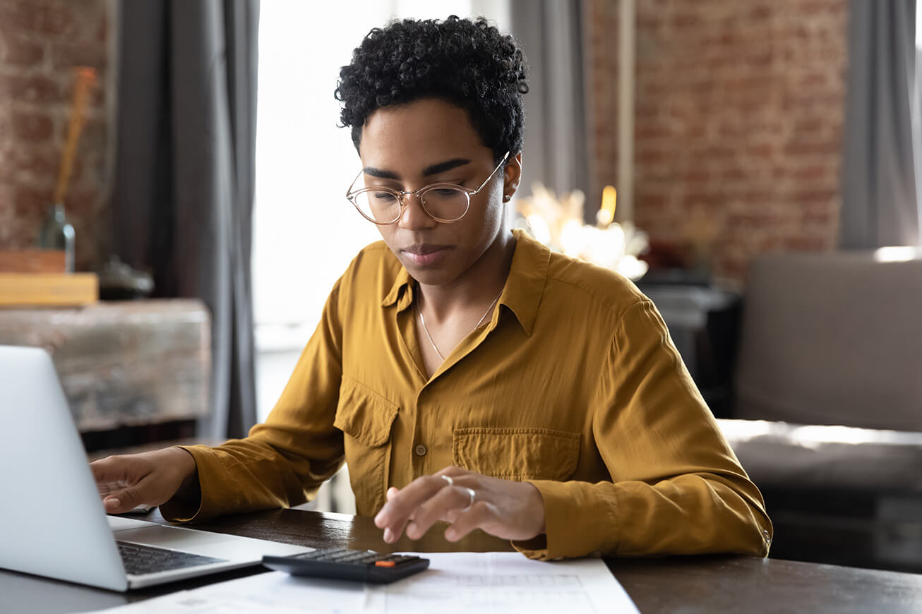 A young woman calculates how much she may save by using the IRA contributions deduction. 