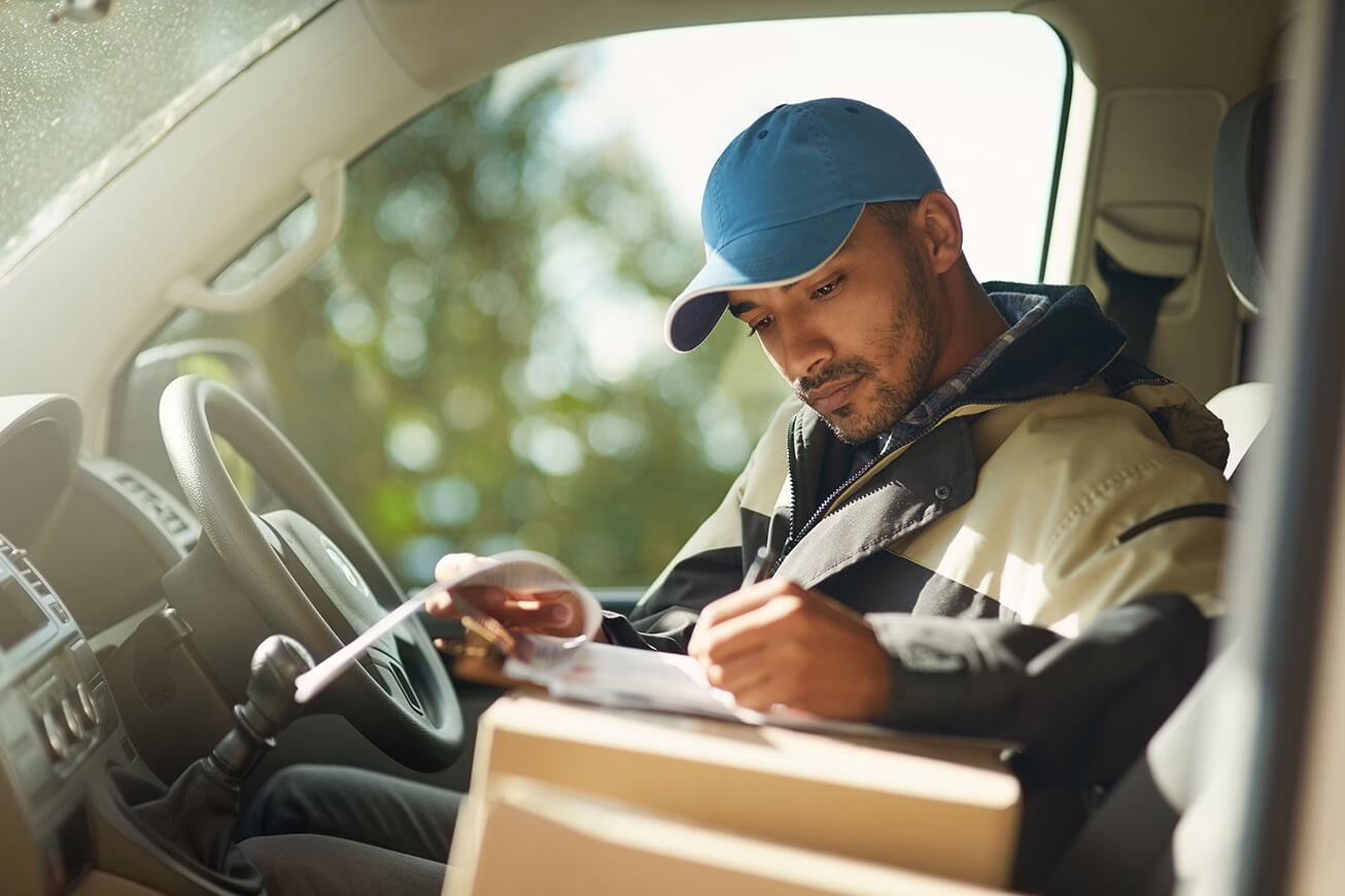 A young man drives a business vehicle. 