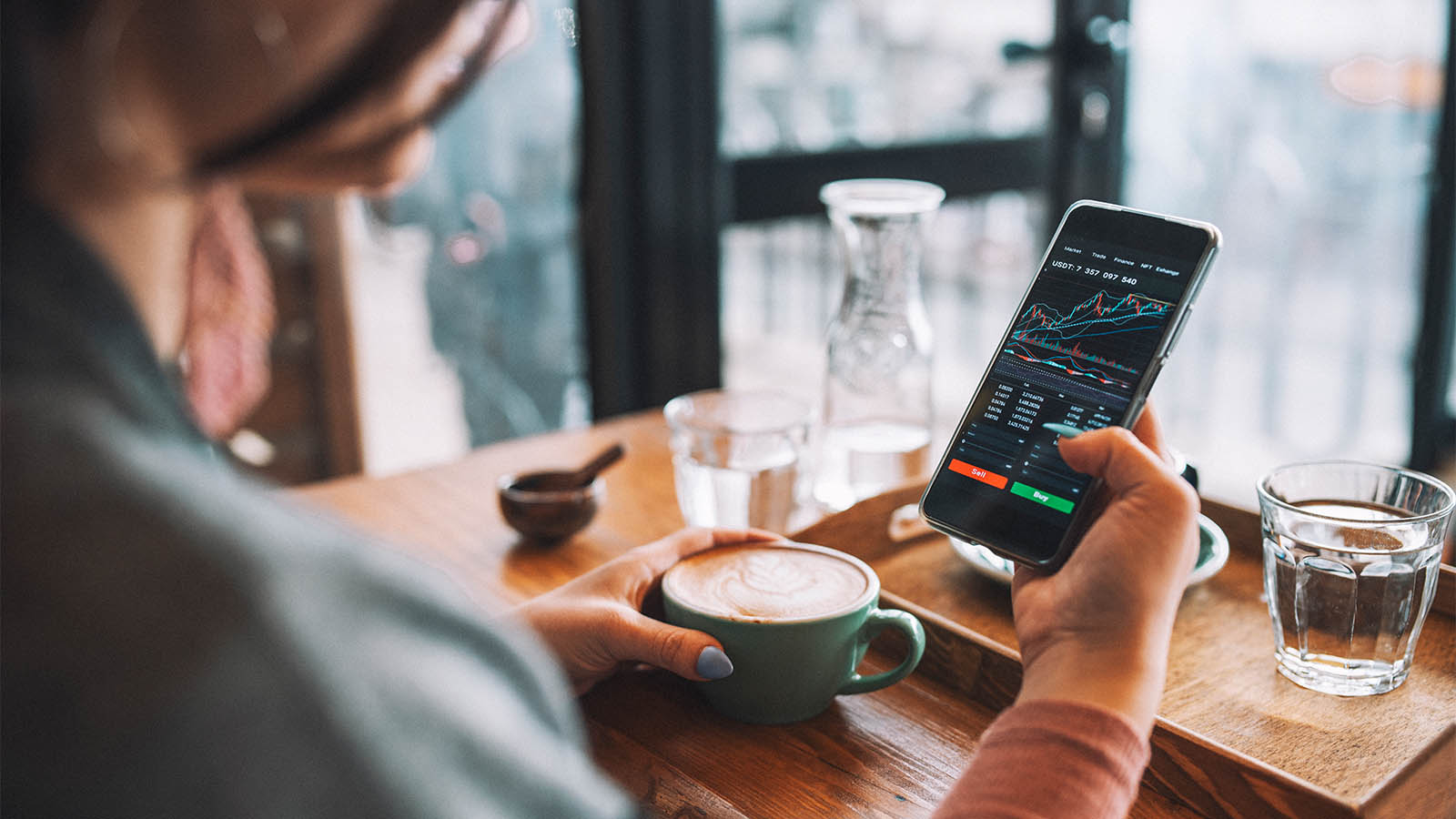 A person buys stocks on their mobile phone.