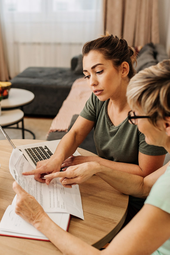 Two women calculate their income taxes.